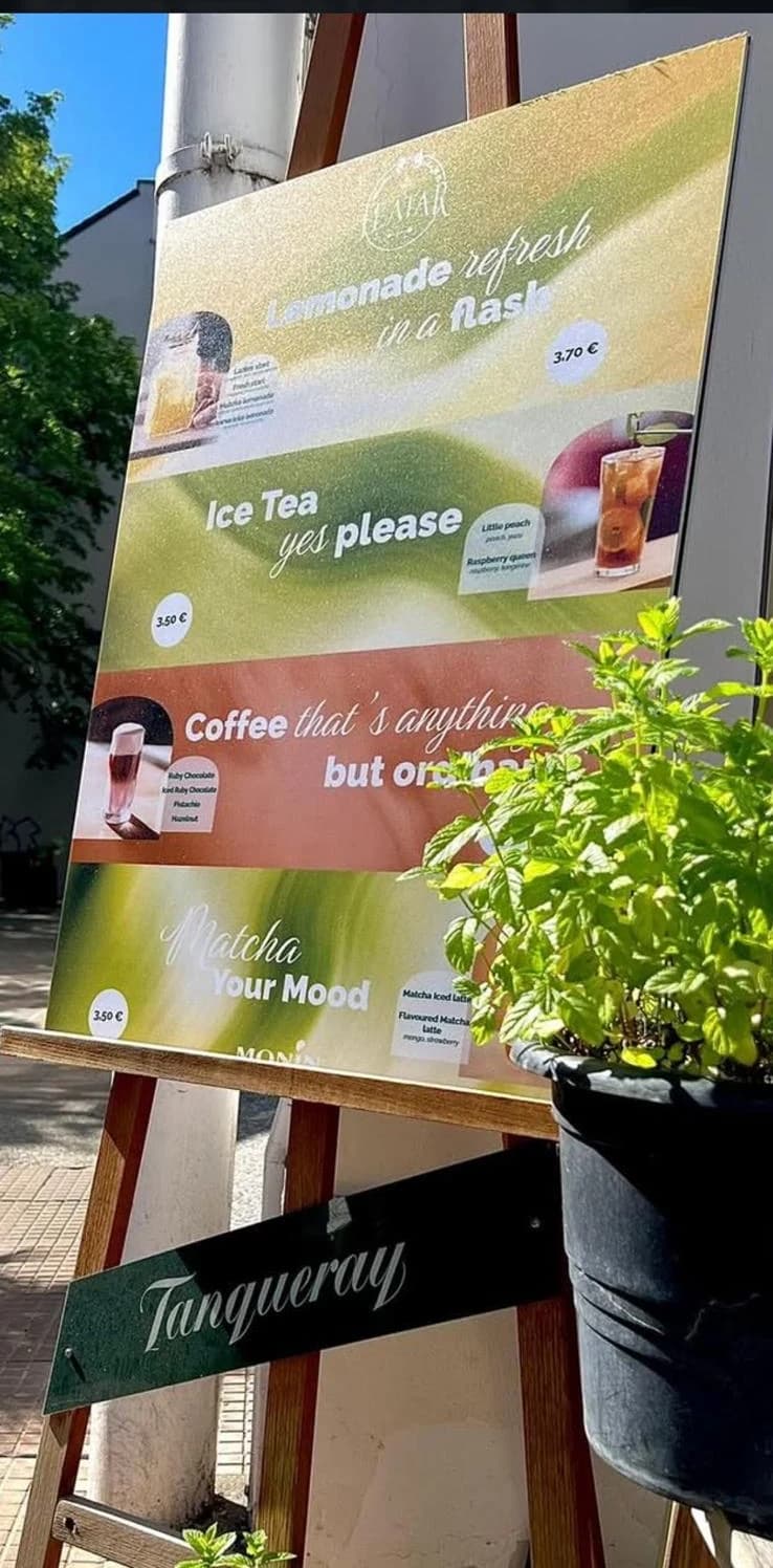 Ploča s ponudom limunada, ledenih čajeva, kave i matche ispred bara